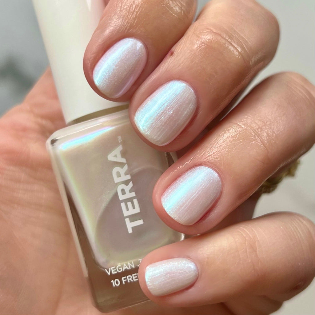 No. 45 Glazed (pearlescent shimmer that is now a classic staple) swatched on hands and holding terra bottle.
