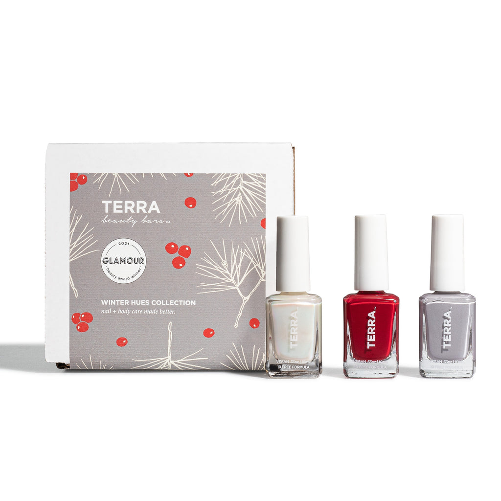 Winter Hues holiday nail kit in white box, festive holiday label and three TERRA nail colors to include: No. 3 Gray (a Terra Founder Fav, this color works all year long and sits between a true light cement to cooler blue-gray shade); No. 45 Glazed (pearlescent shimmer that is now a classic staple); and No. 46 Crimson (a captivating red wine hue).